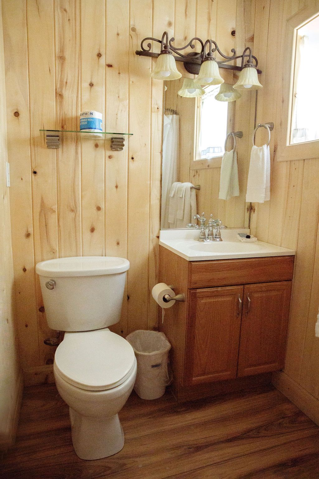 A bathroom with a toilet , sink and mirror.