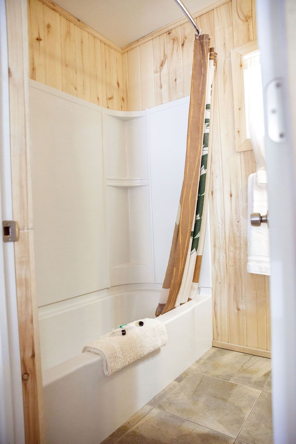 A bathroom with a bathtub and a shower curtain.