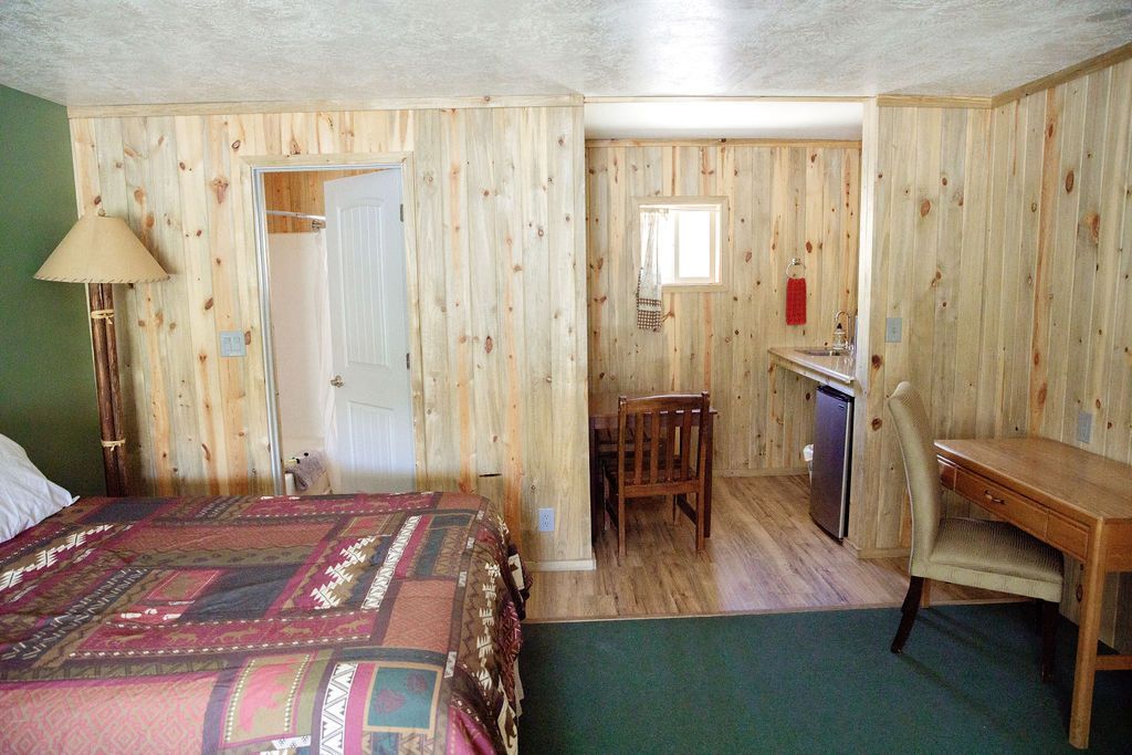 A hotel room with a bed and a table and chairs