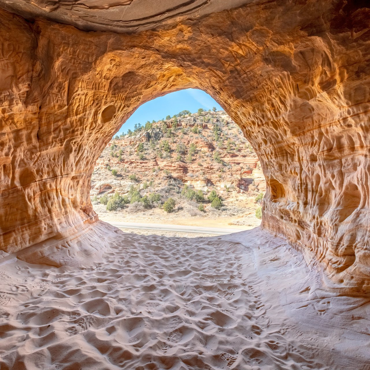 the inside of a cave with a view of the mountains