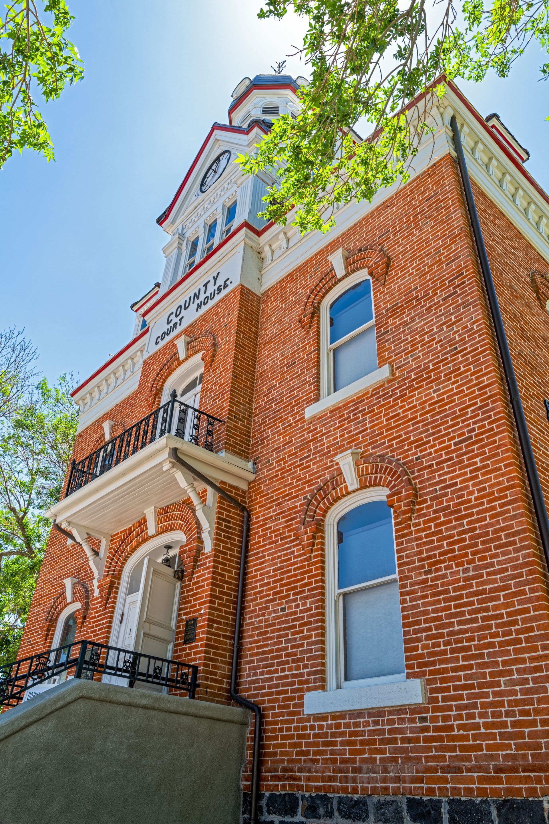 A large brick building with a balcony and a clock tower.