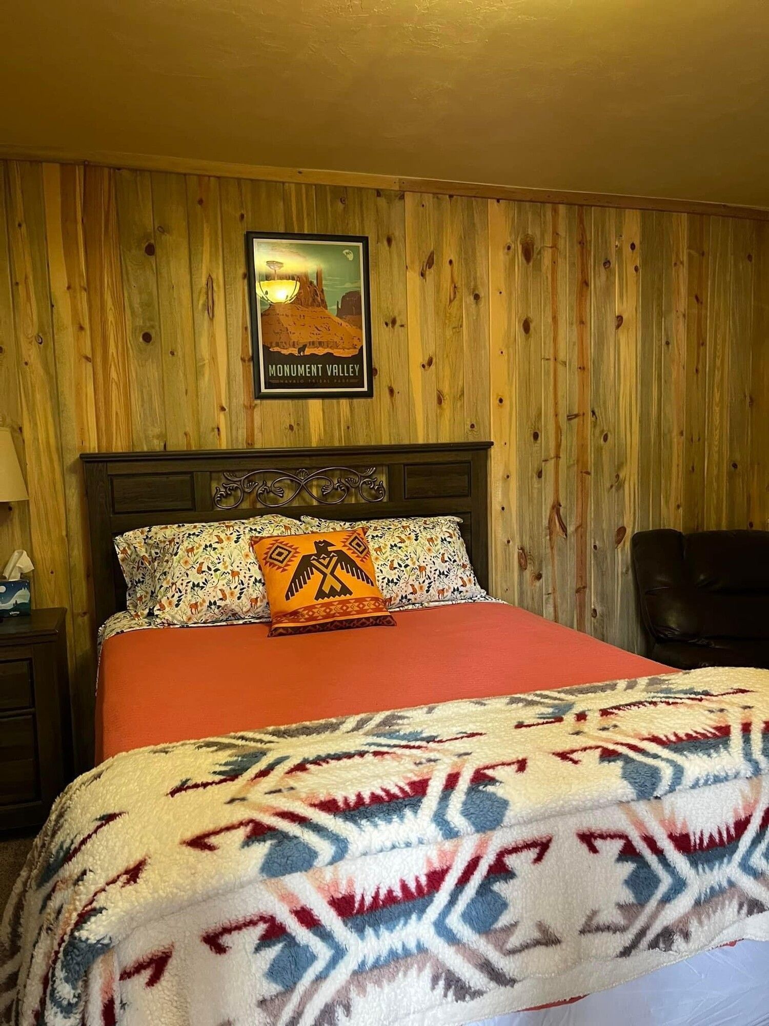 A bedroom with a bed and a picture on the wall.