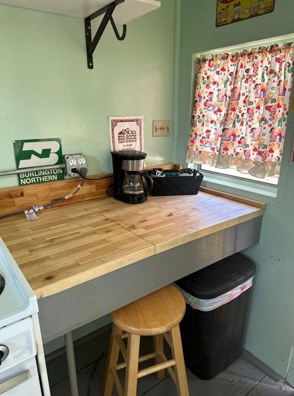 A kitchen with a wooden table and a coffee maker