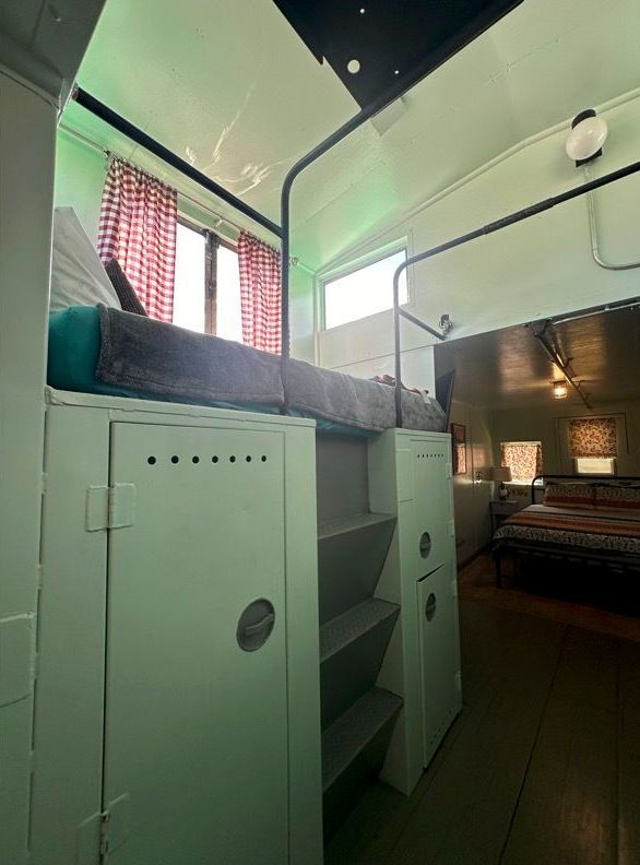 A bedroom with a bunk bed and stairs leading up to it.