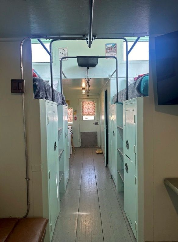 A long hallway filled with lockers and bunk beds.