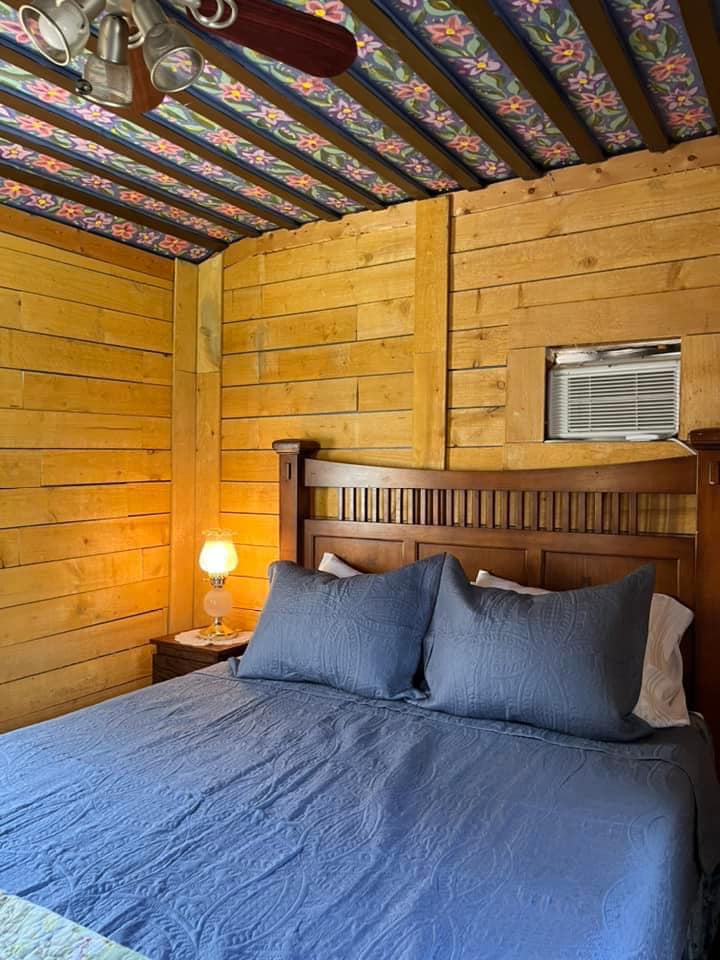 A bedroom with a bed and a ceiling fan.
