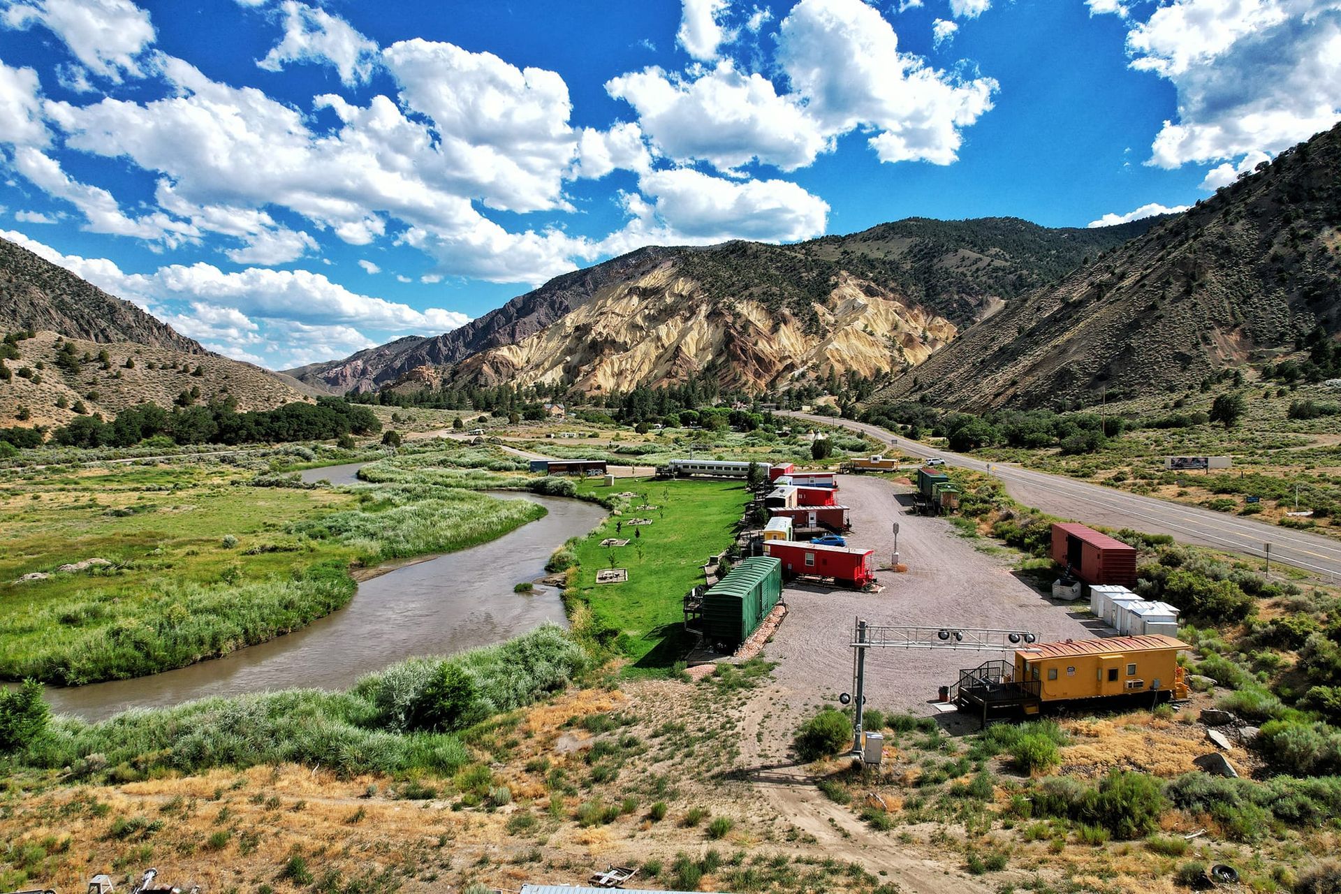 An aerial view of a train yard with mountains in the background.