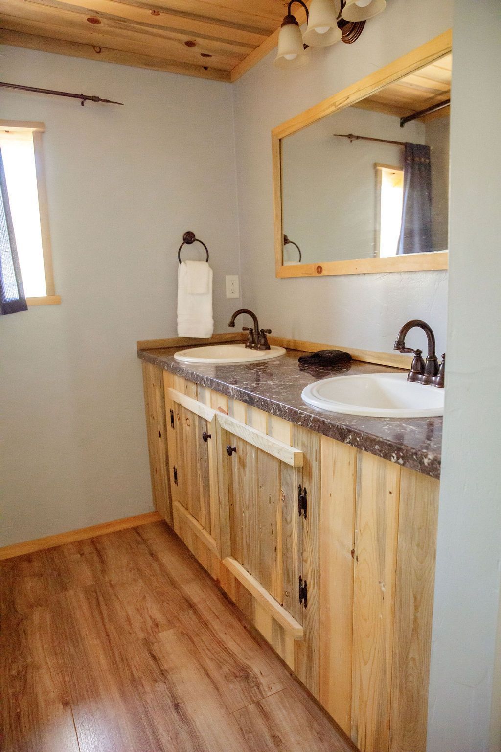 A bathroom with two sinks and a large mirror.