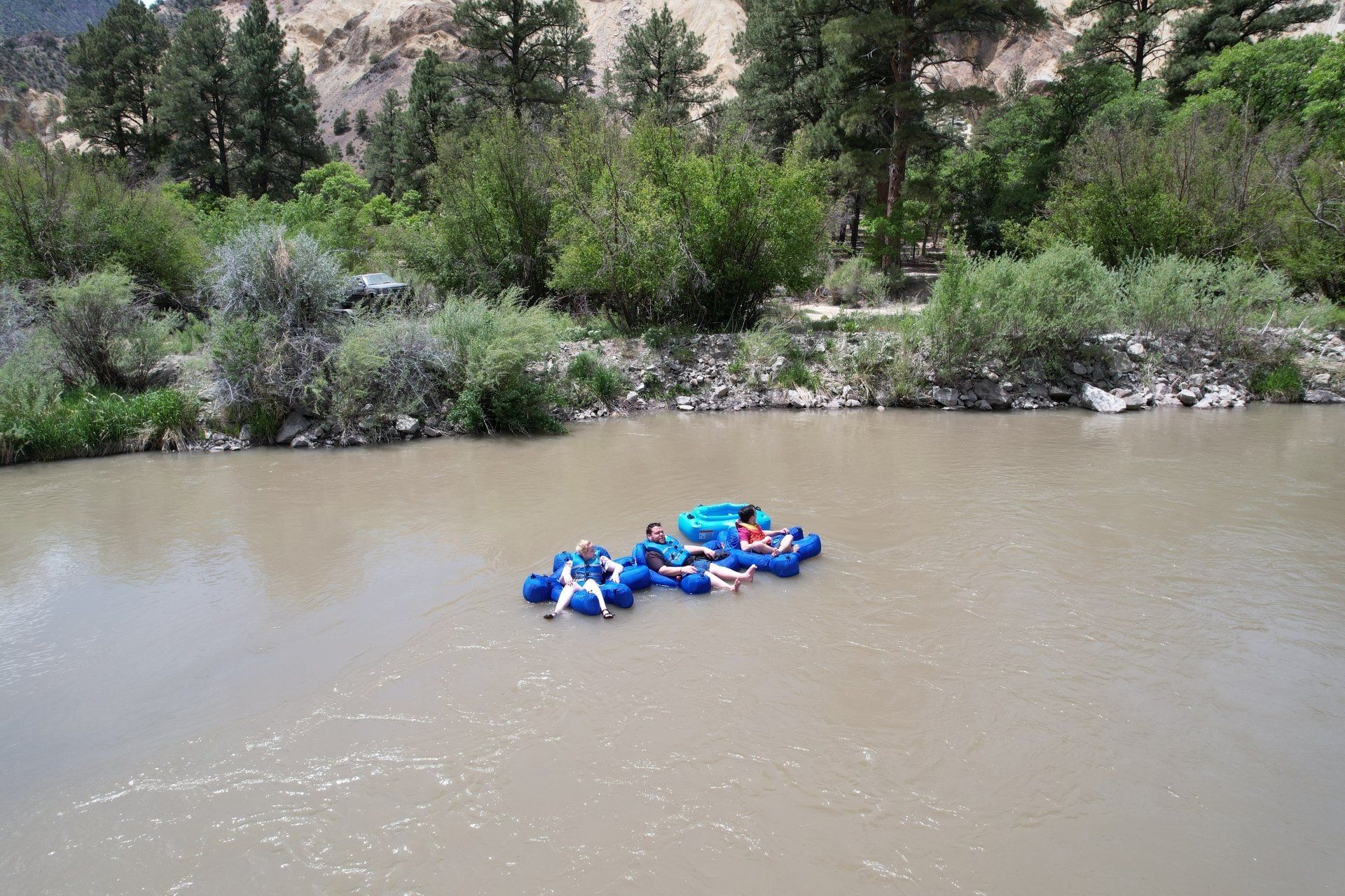 A group of people are floating on rafts in a river.
