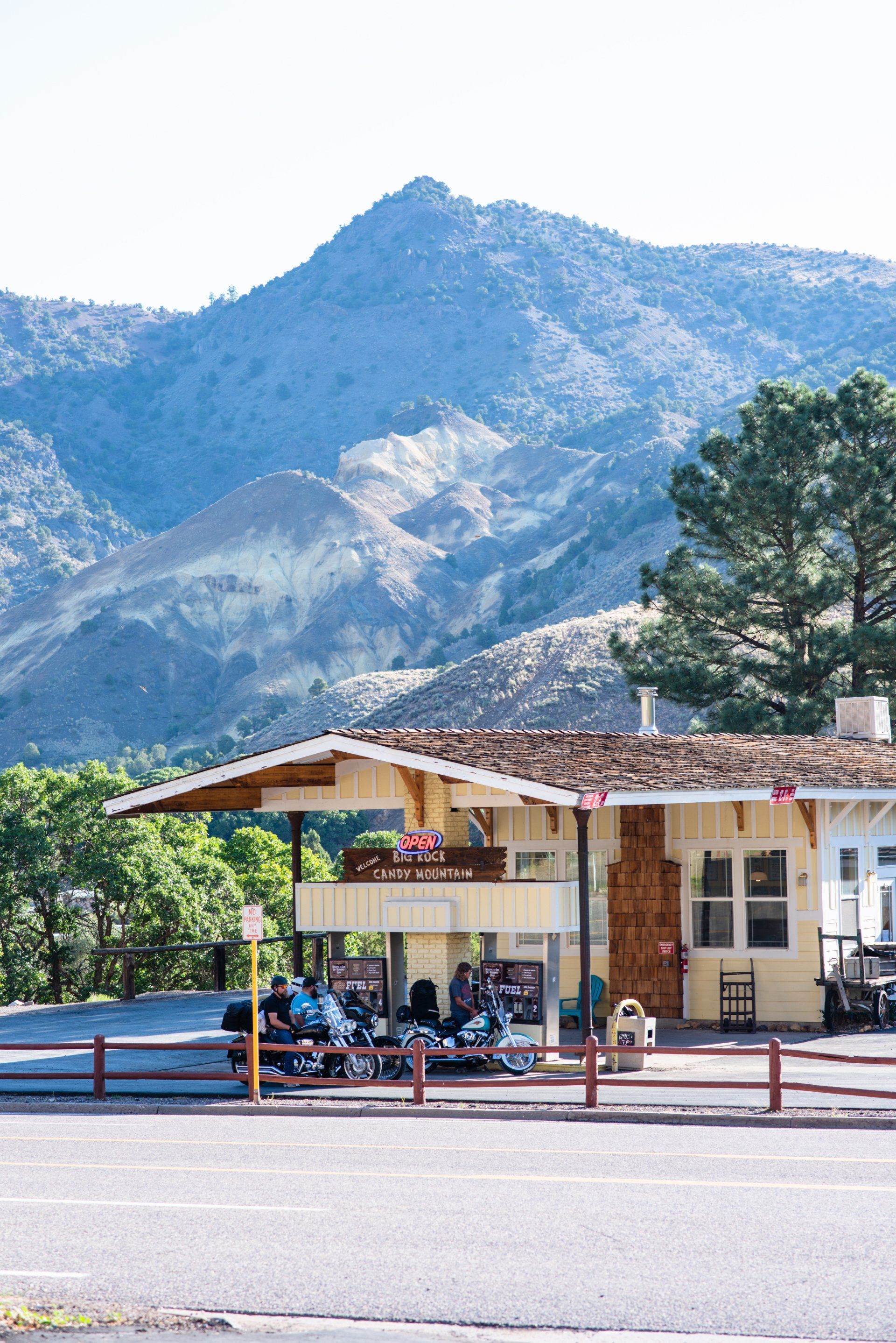 A house with motorcycles parked in front of it with mountains in the background.