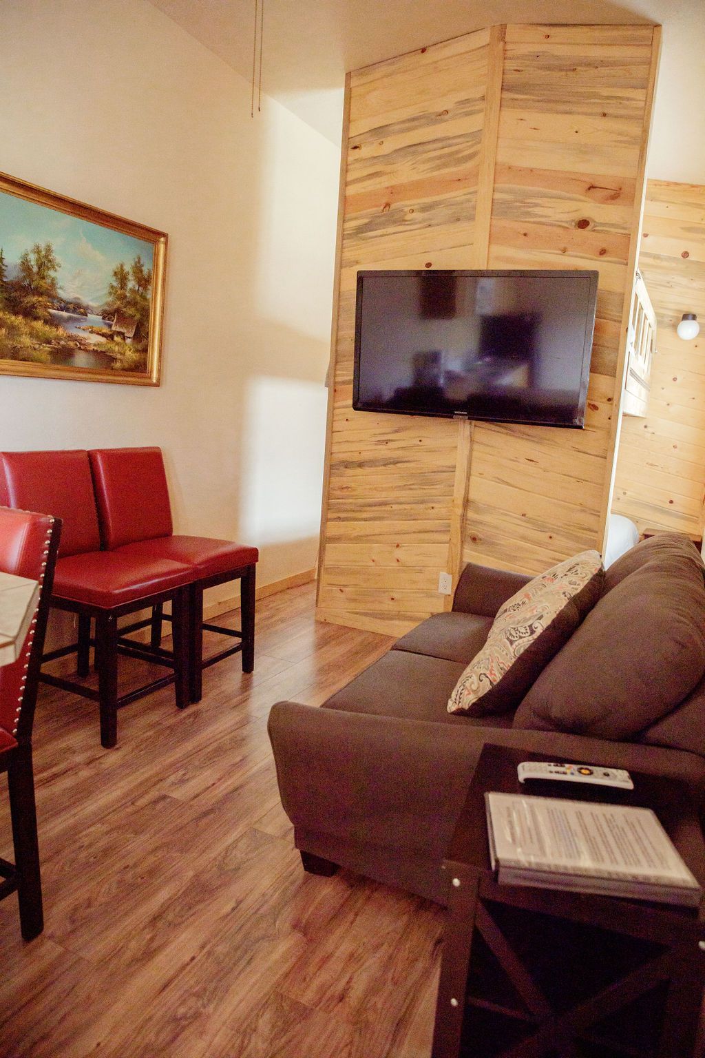 A living room with a couch , chairs and a flat screen tv.