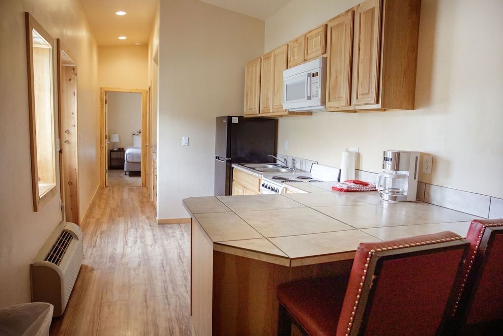 A hotel room with a kitchen and a bar