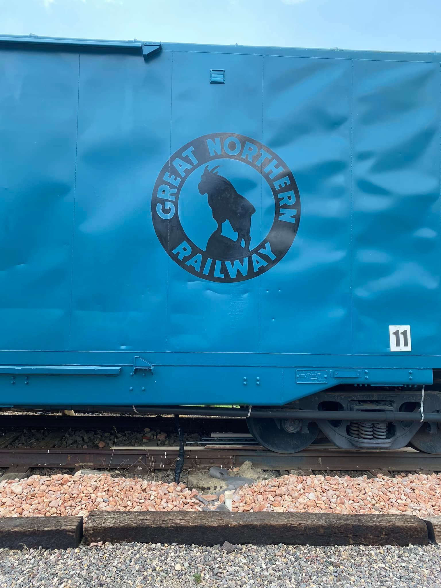 A blue train car with the words great northern railway painted on it