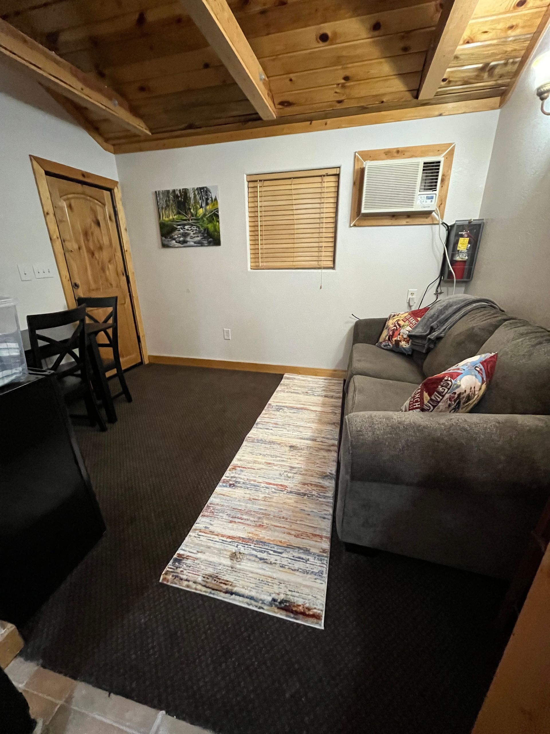 A living room with a couch , chairs , and a rug.