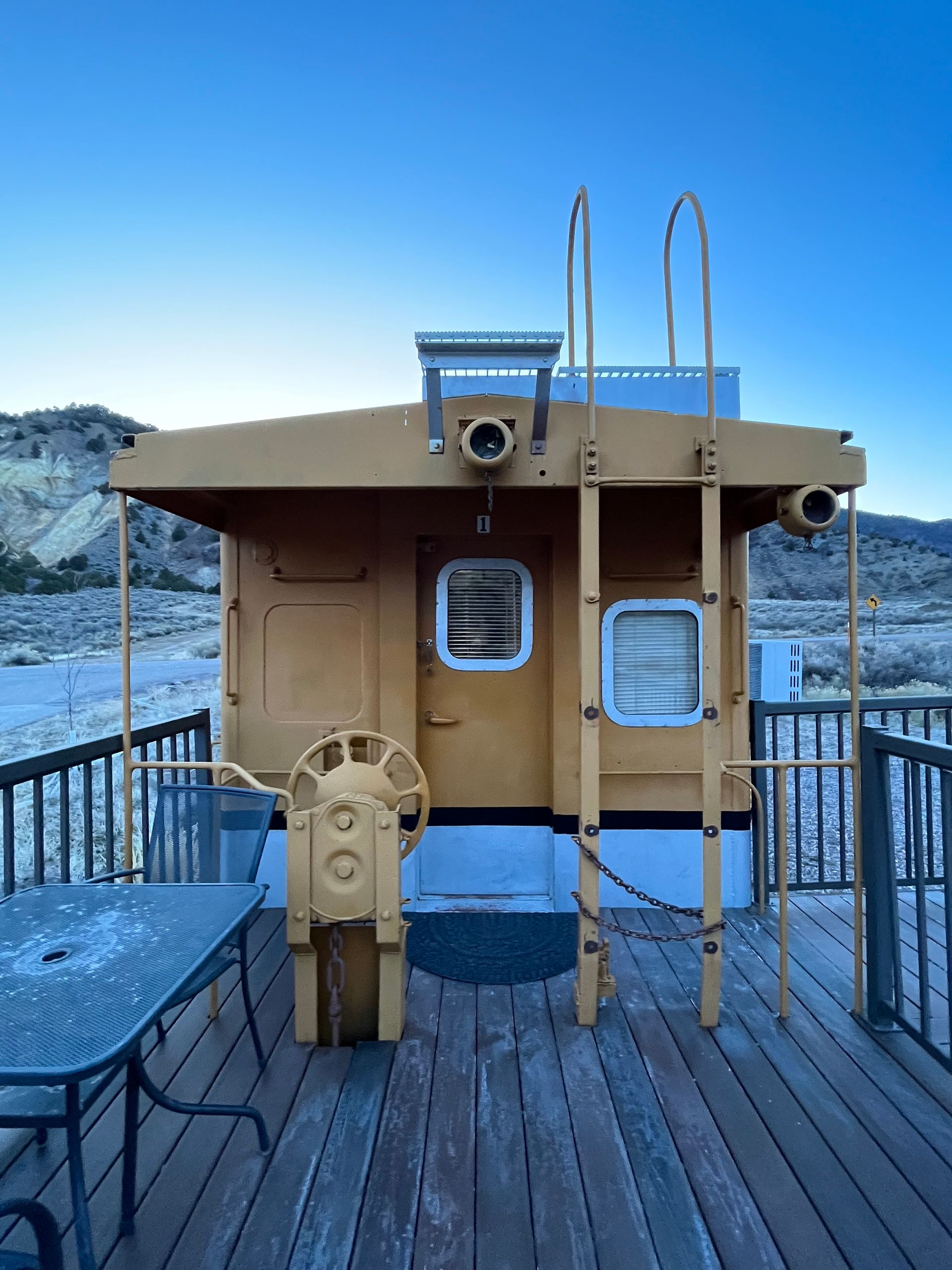 A wooden deck with a boat on it and a table and chairs