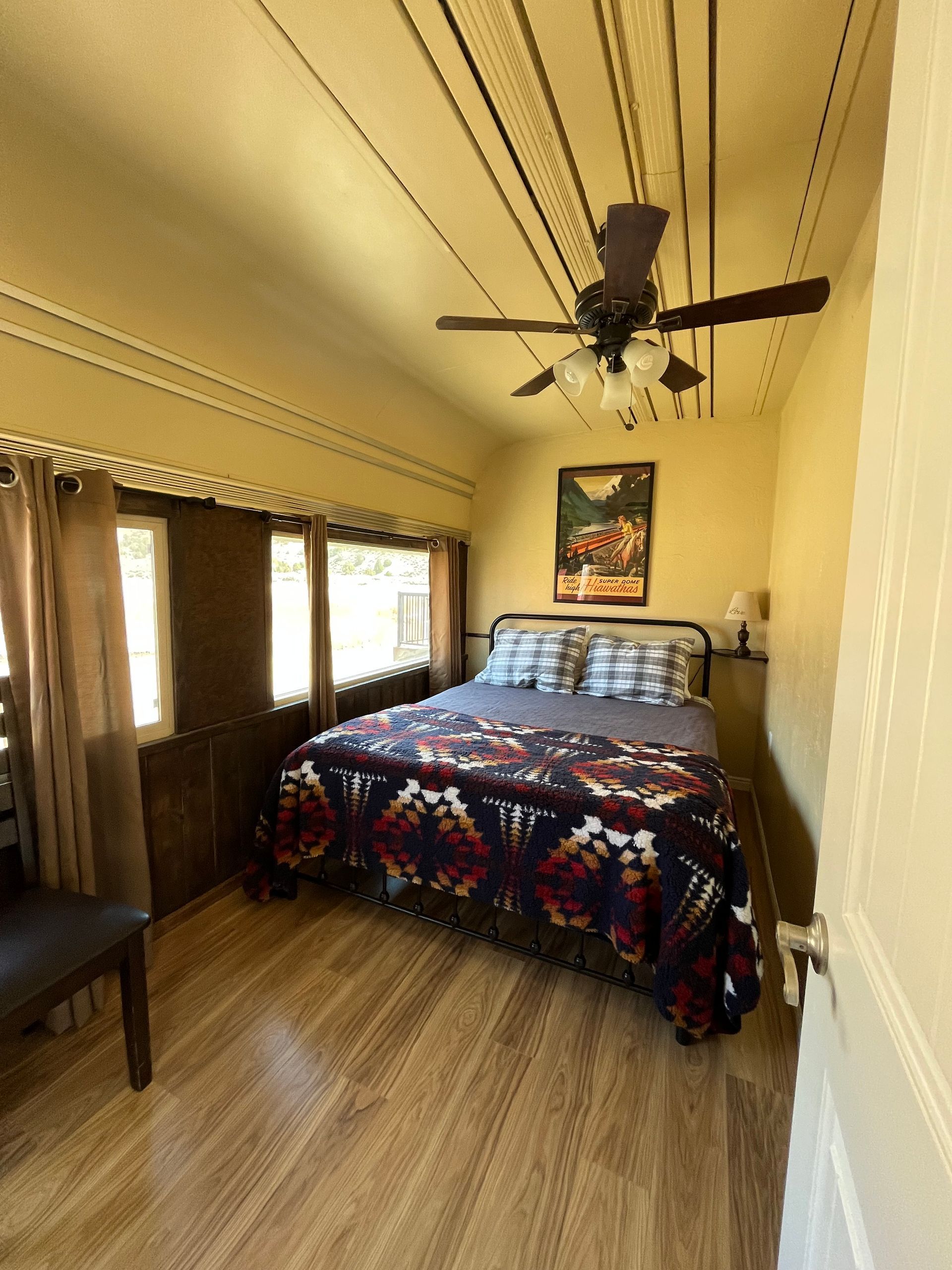 A bedroom with a bed and a ceiling fan