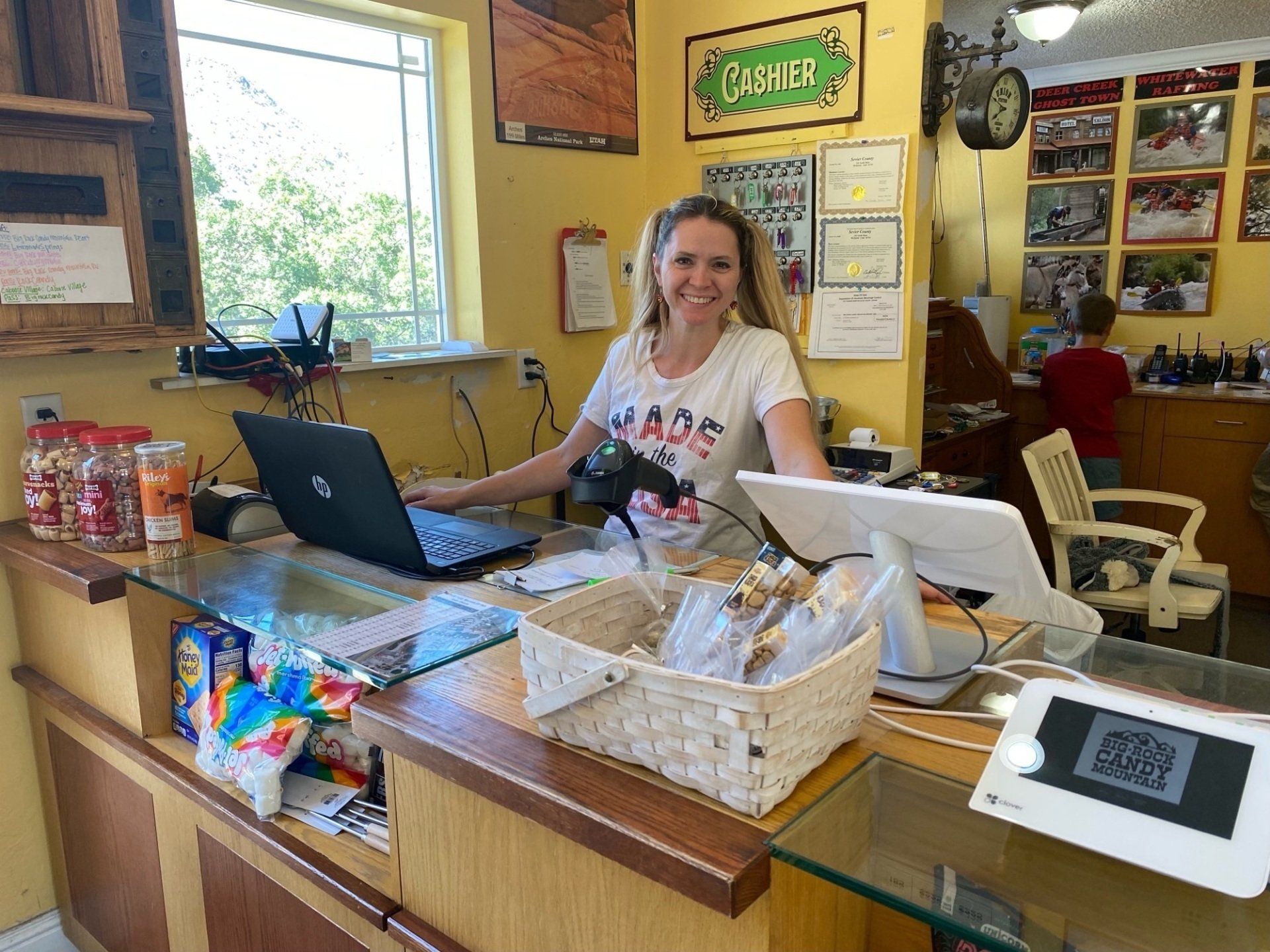 A woman is sitting at a counter with a laptop.