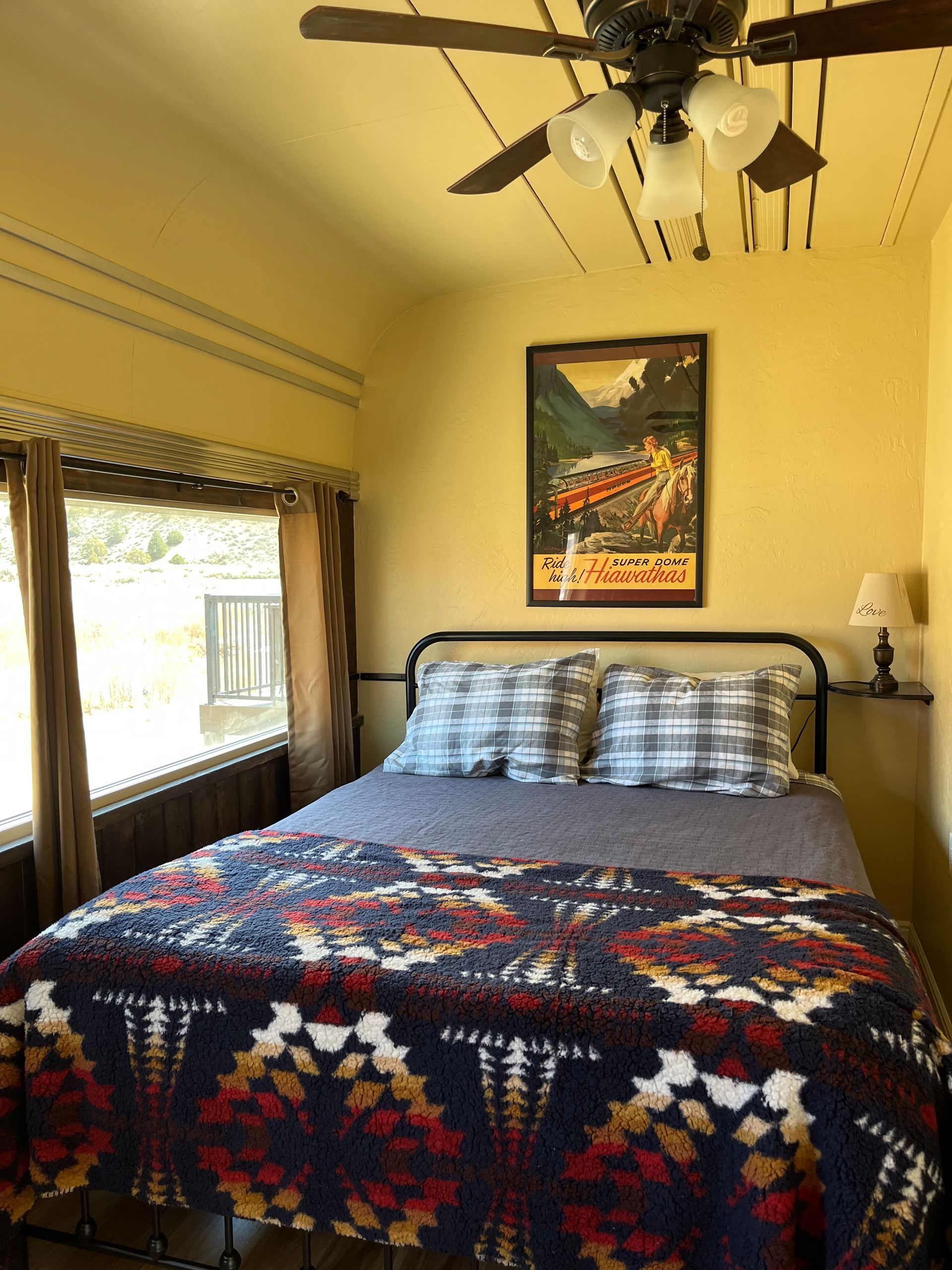 A bedroom with a bed and a ceiling fan.