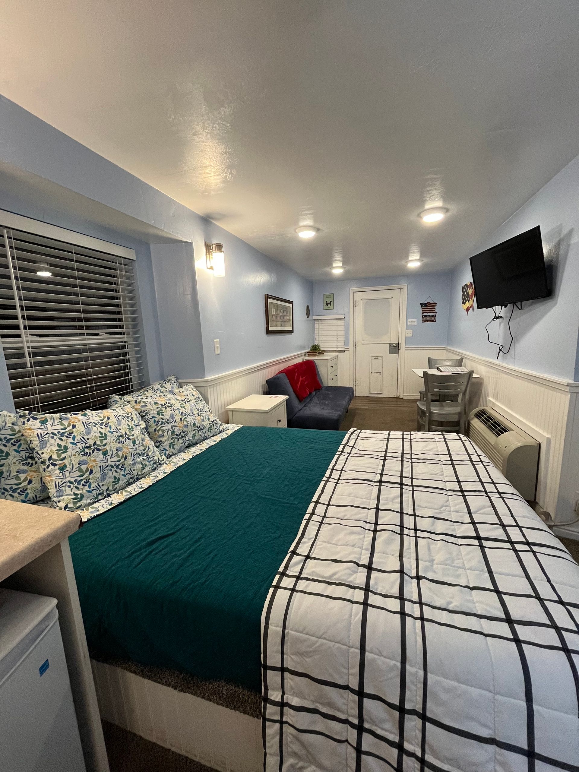 A hotel room with a king size bed and a flat screen tv.