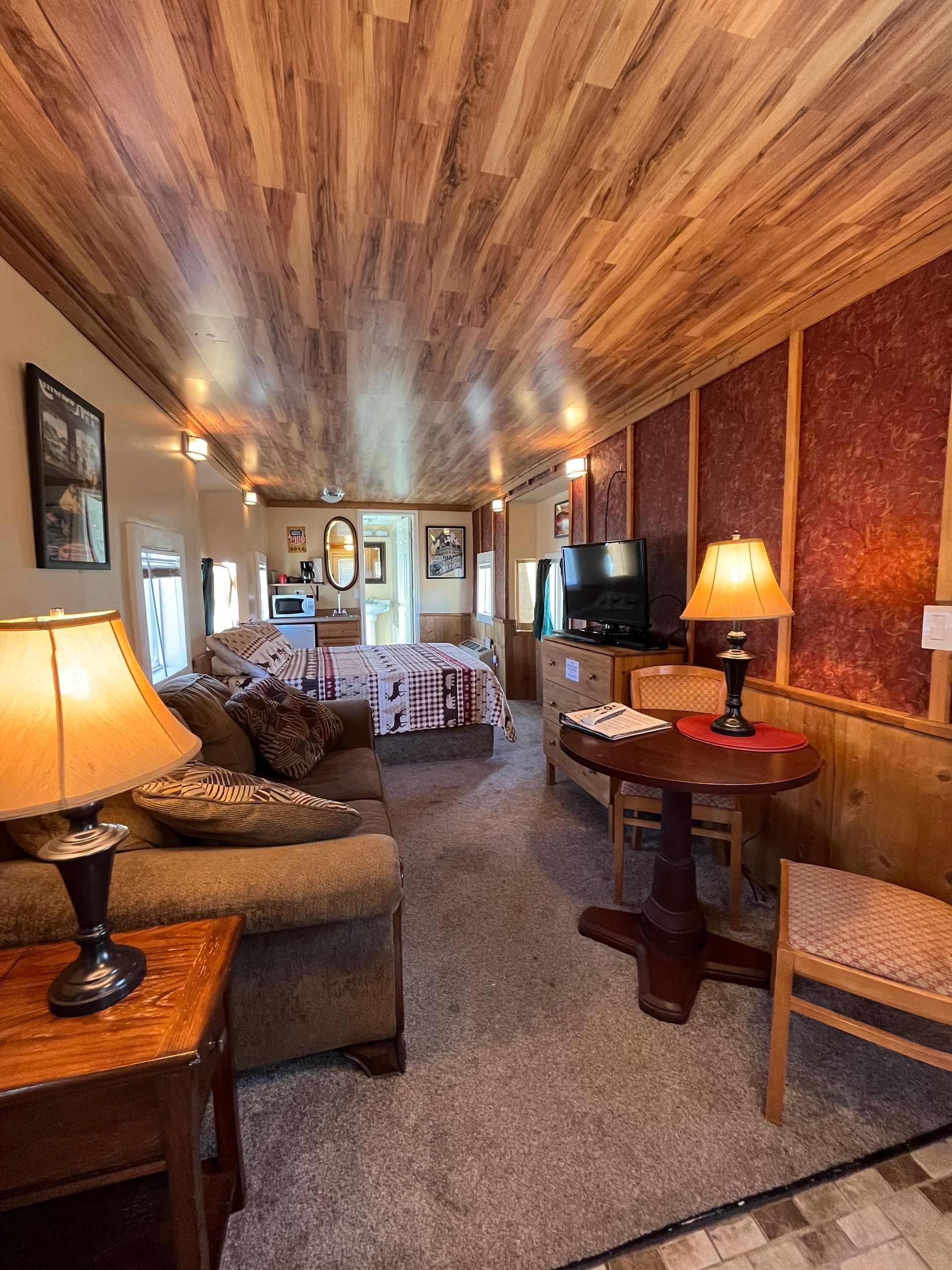 A living room with a couch , table , chairs and lamps.