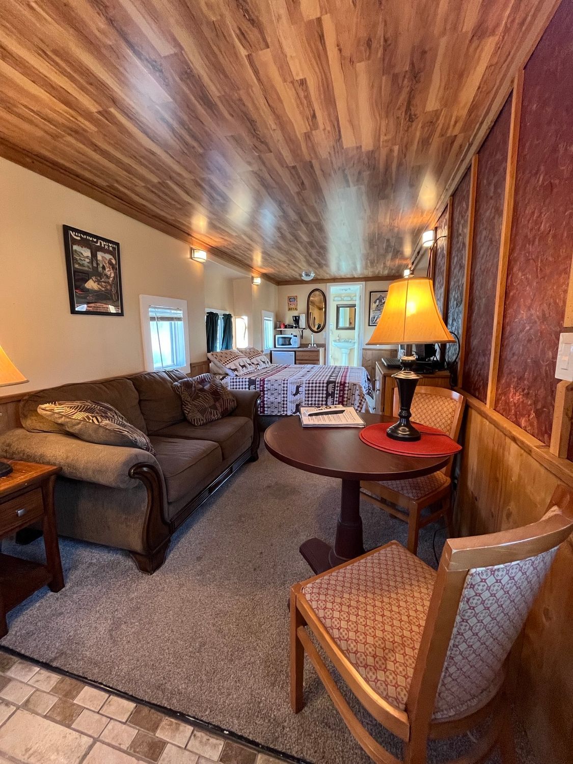 A living room with a couch , table , chairs and lamps.