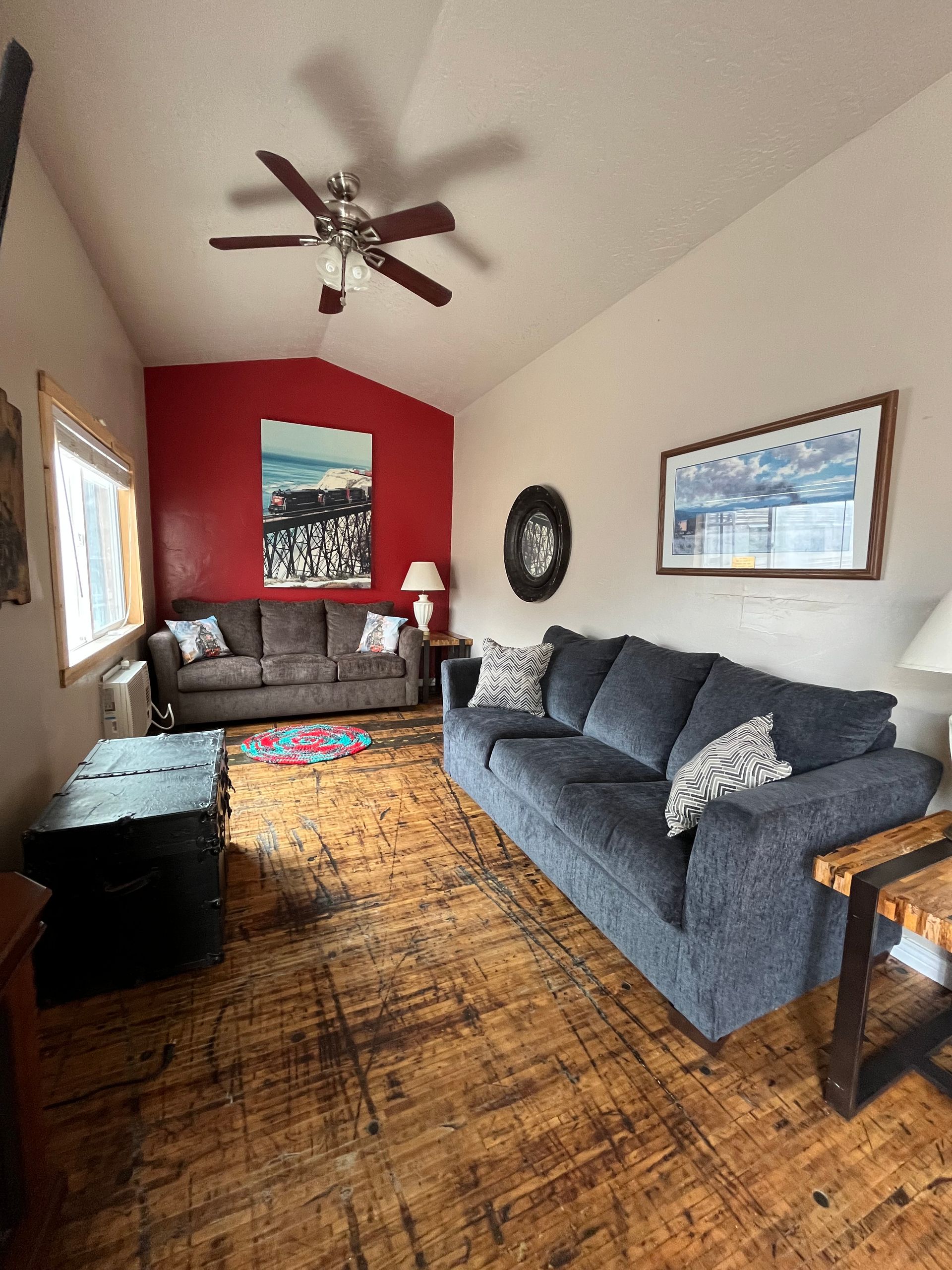 A living room with a couch and a ceiling fan.