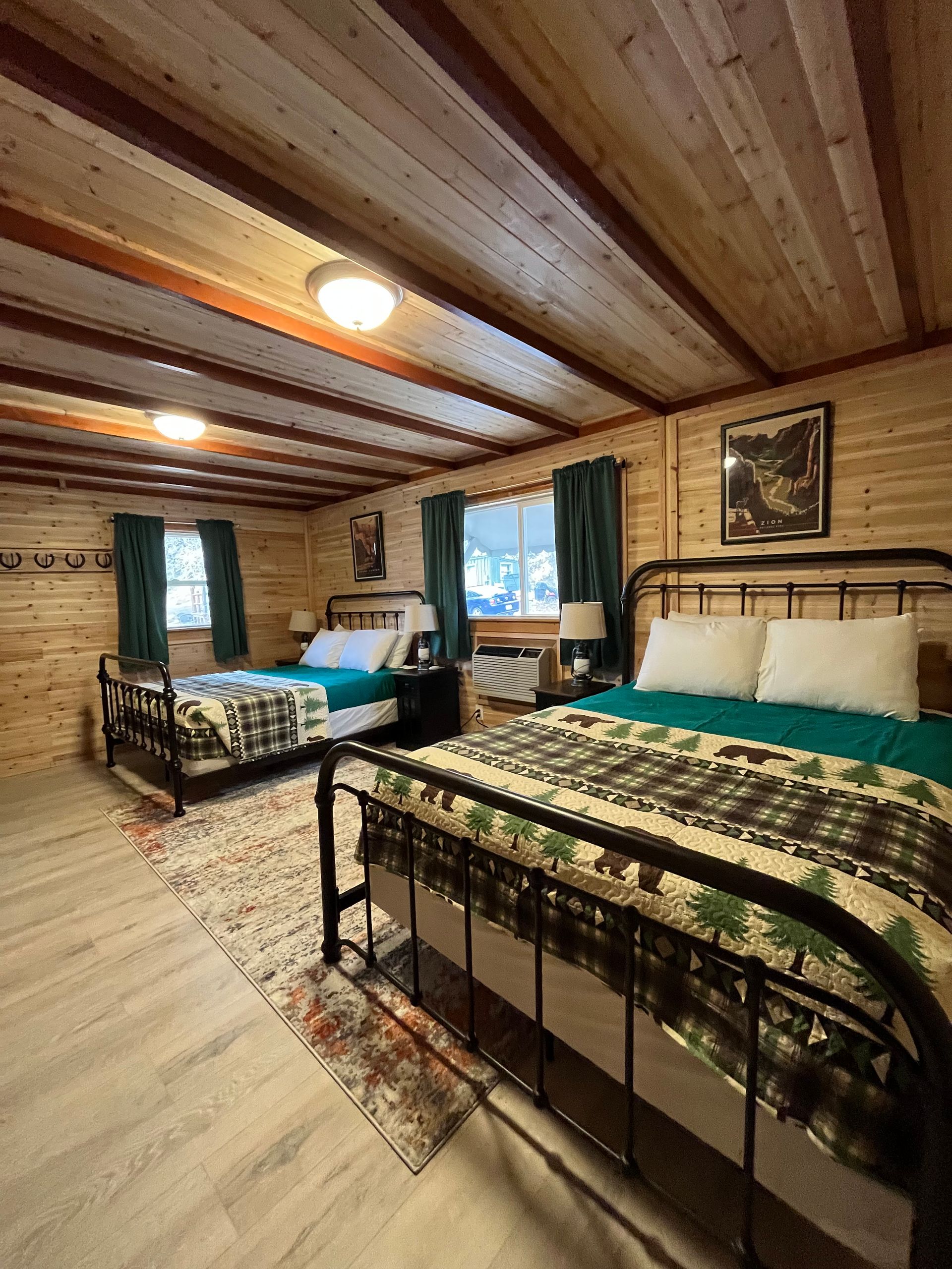 A bedroom with two beds and a wooden ceiling.