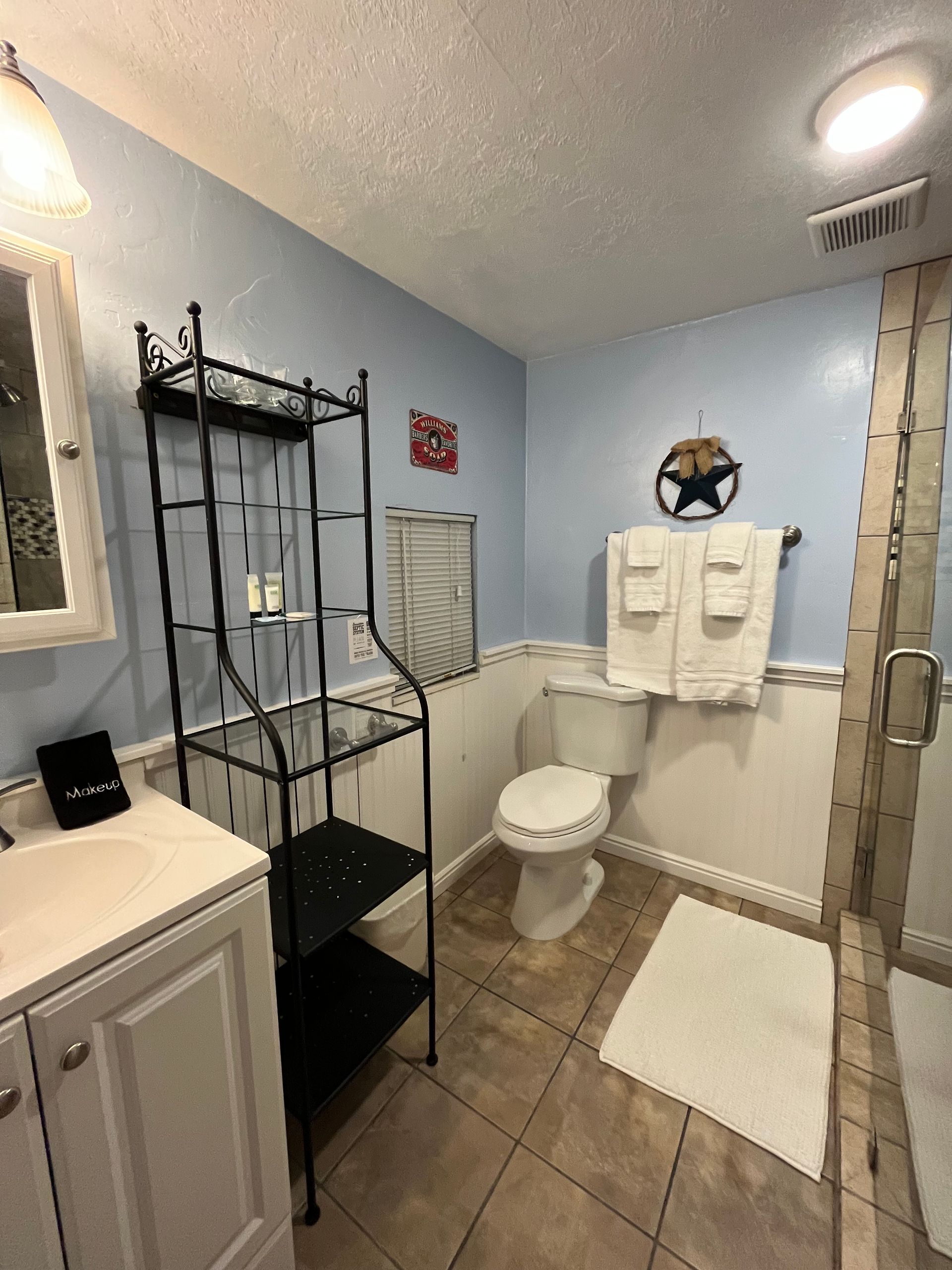 A bathroom with a toilet , sink , and shower.