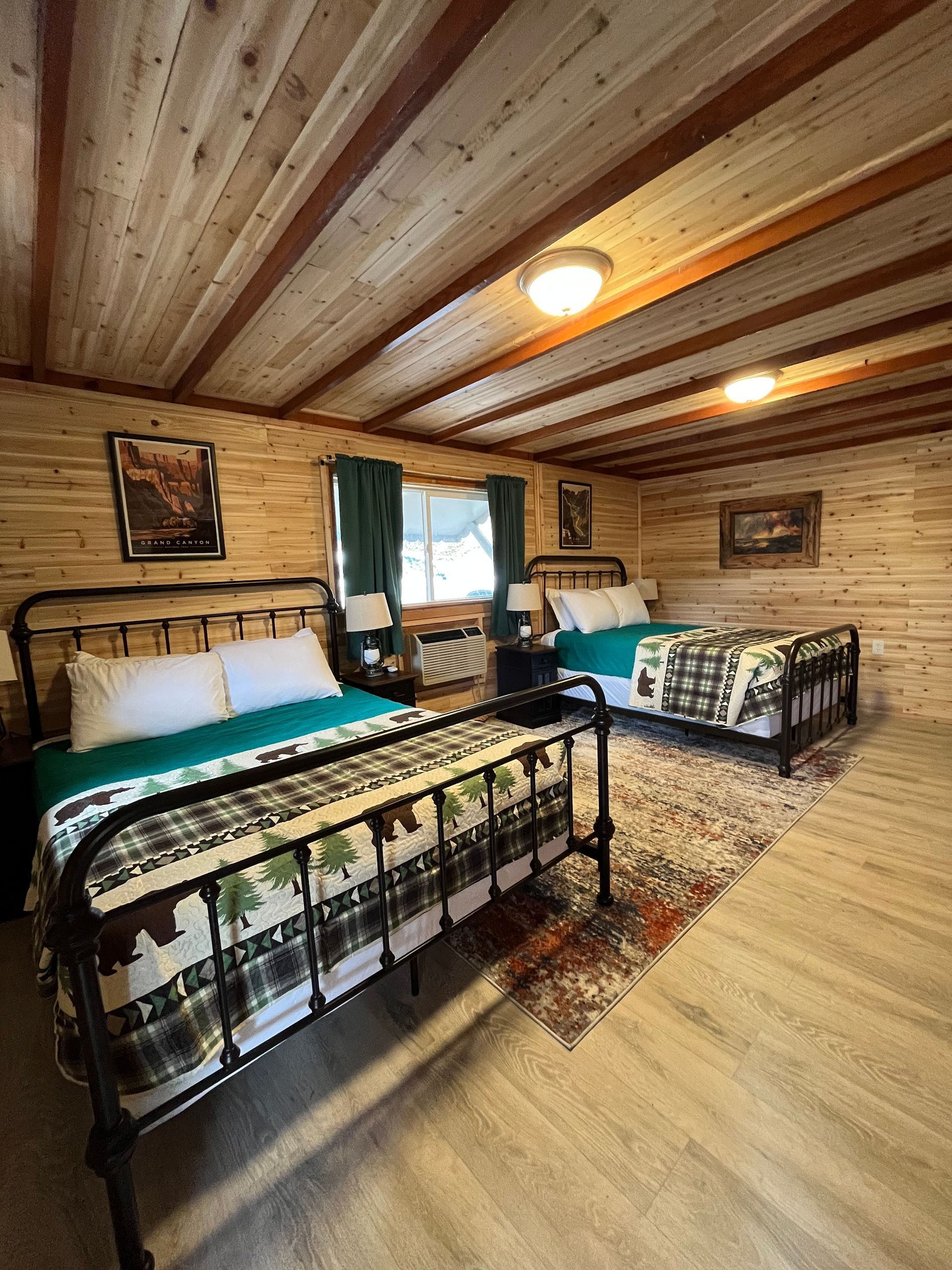 A bedroom with two beds and a wooden ceiling.