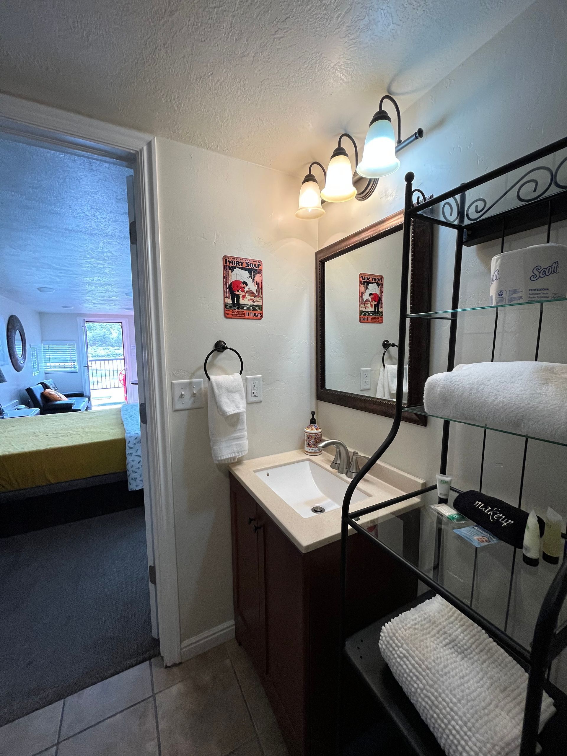 A bathroom with a sink , mirror and towels.