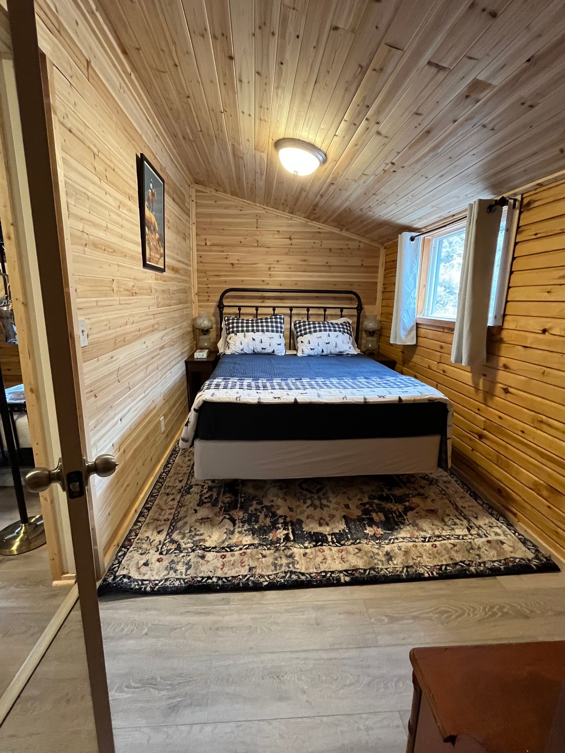 A bedroom with a bed and a rug in it.