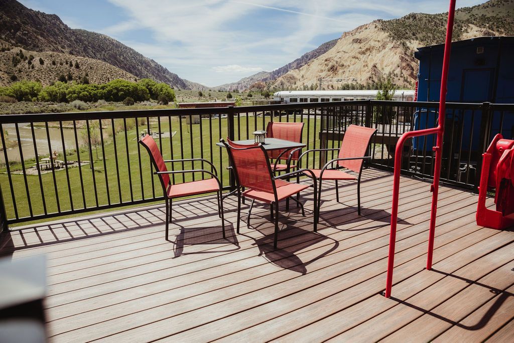 A wooden deck with a table and chairs on it.