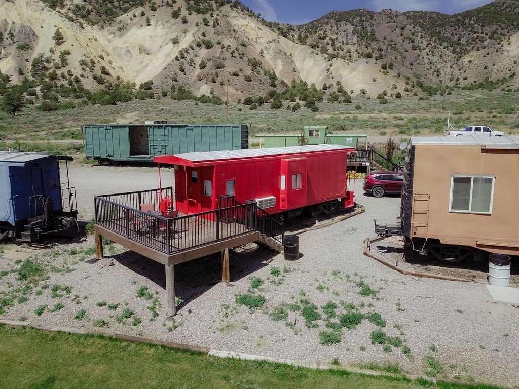 A group of red trailers are parked next to a train car.