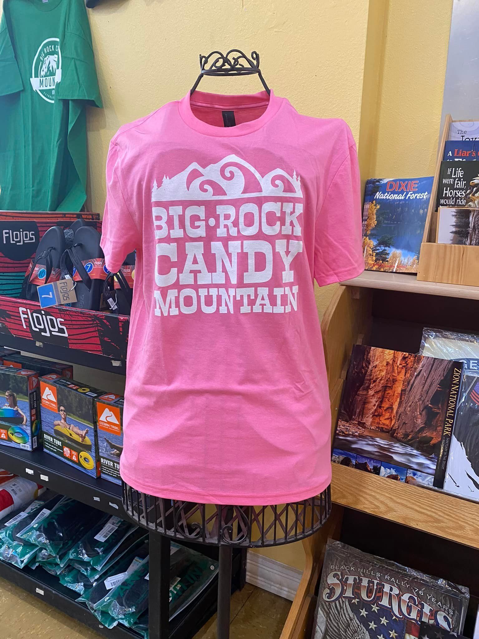 A pink t-shirt is on a mannequin in a store.