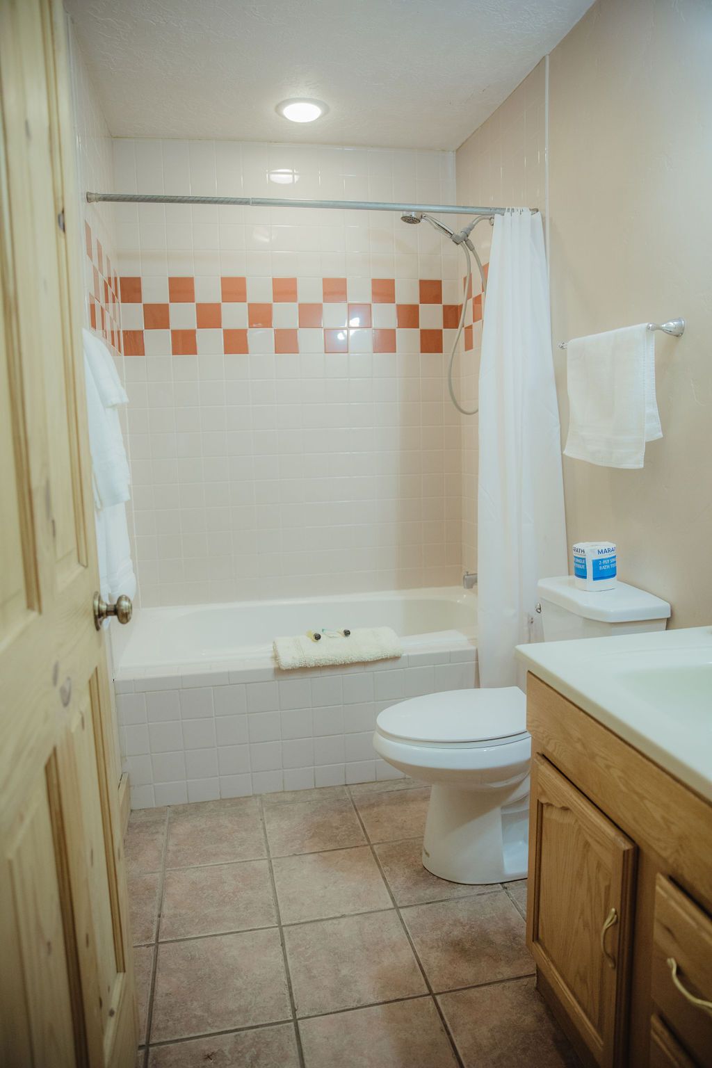 A bathroom with a toilet , sink , tub and shower.