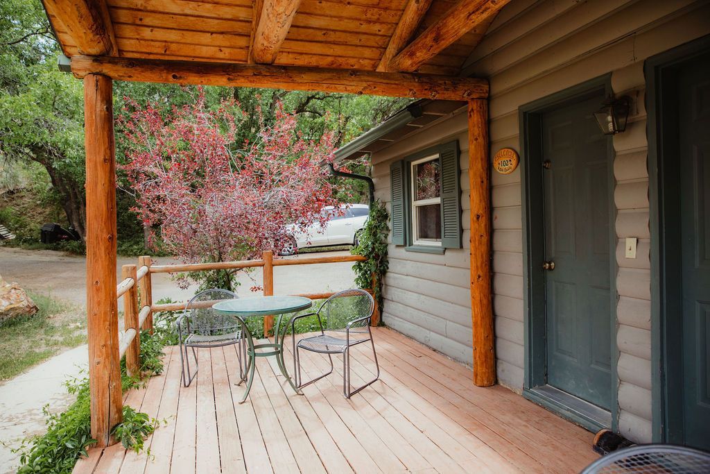 There is a porch with a table and chairs on it.