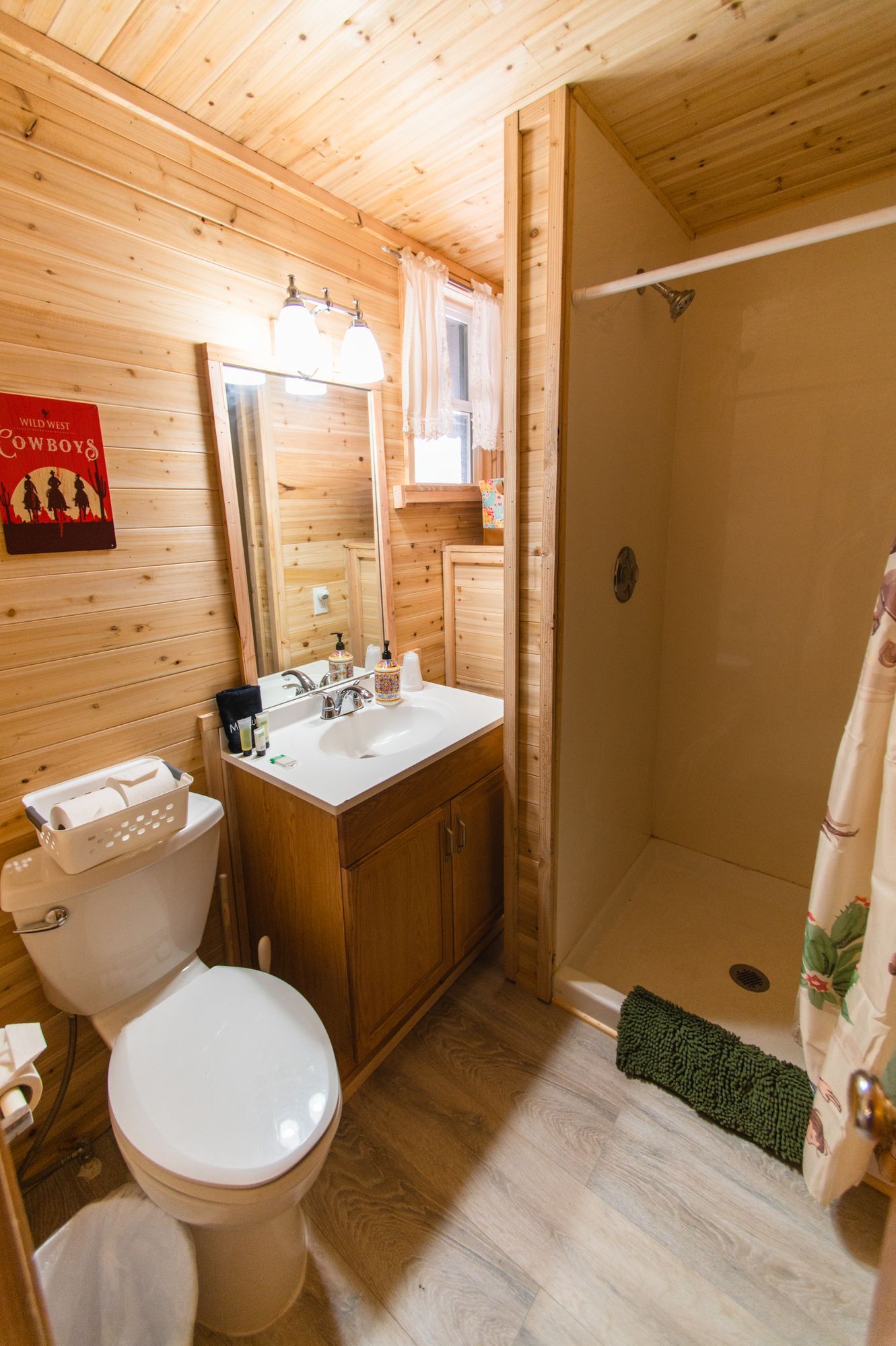 A bathroom with a toilet , sink and shower.