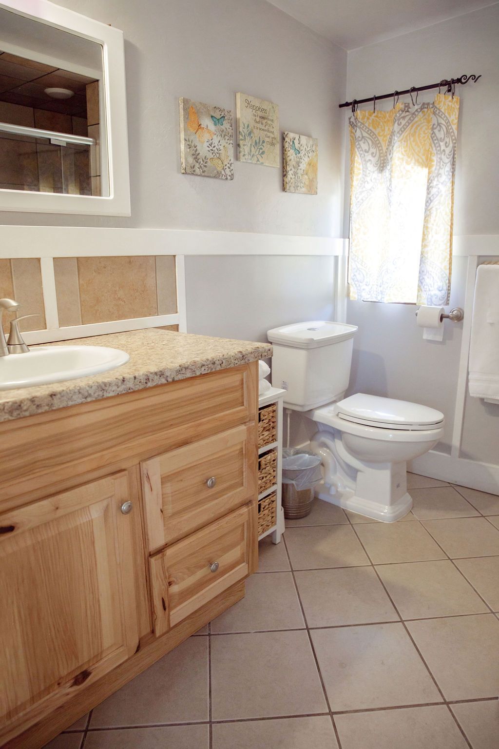 A bathroom with a sink , toilet and mirror.