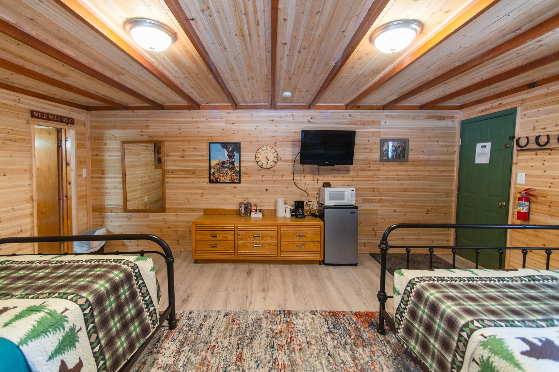 A wooden cabin with two beds and a flat screen tv.