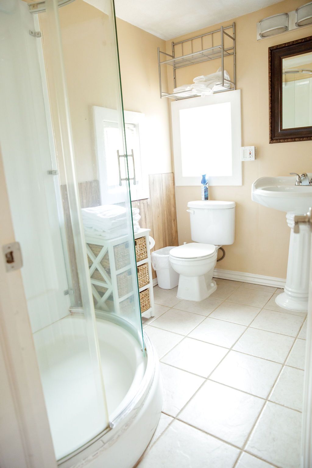 A bathroom with a toilet , sink , shower and mirror.