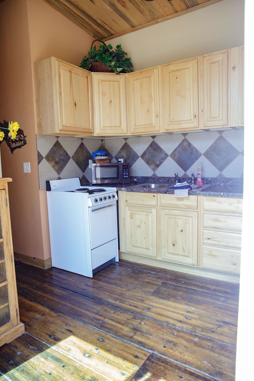 A kitchen with wooden cabinets and a white stove