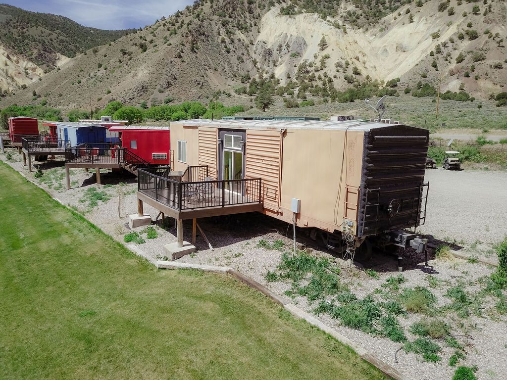 A row of trailers are parked next to a train track.