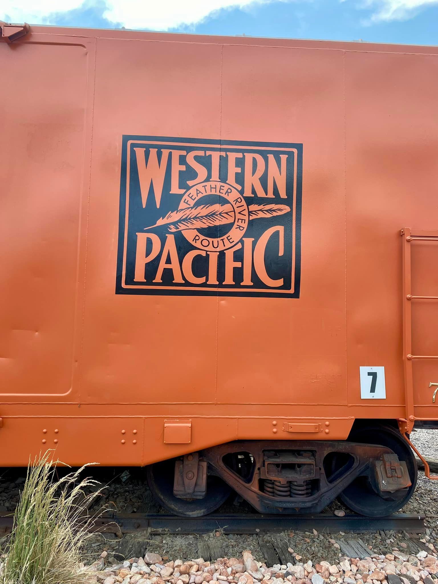 A western pacific train car is parked on the tracks