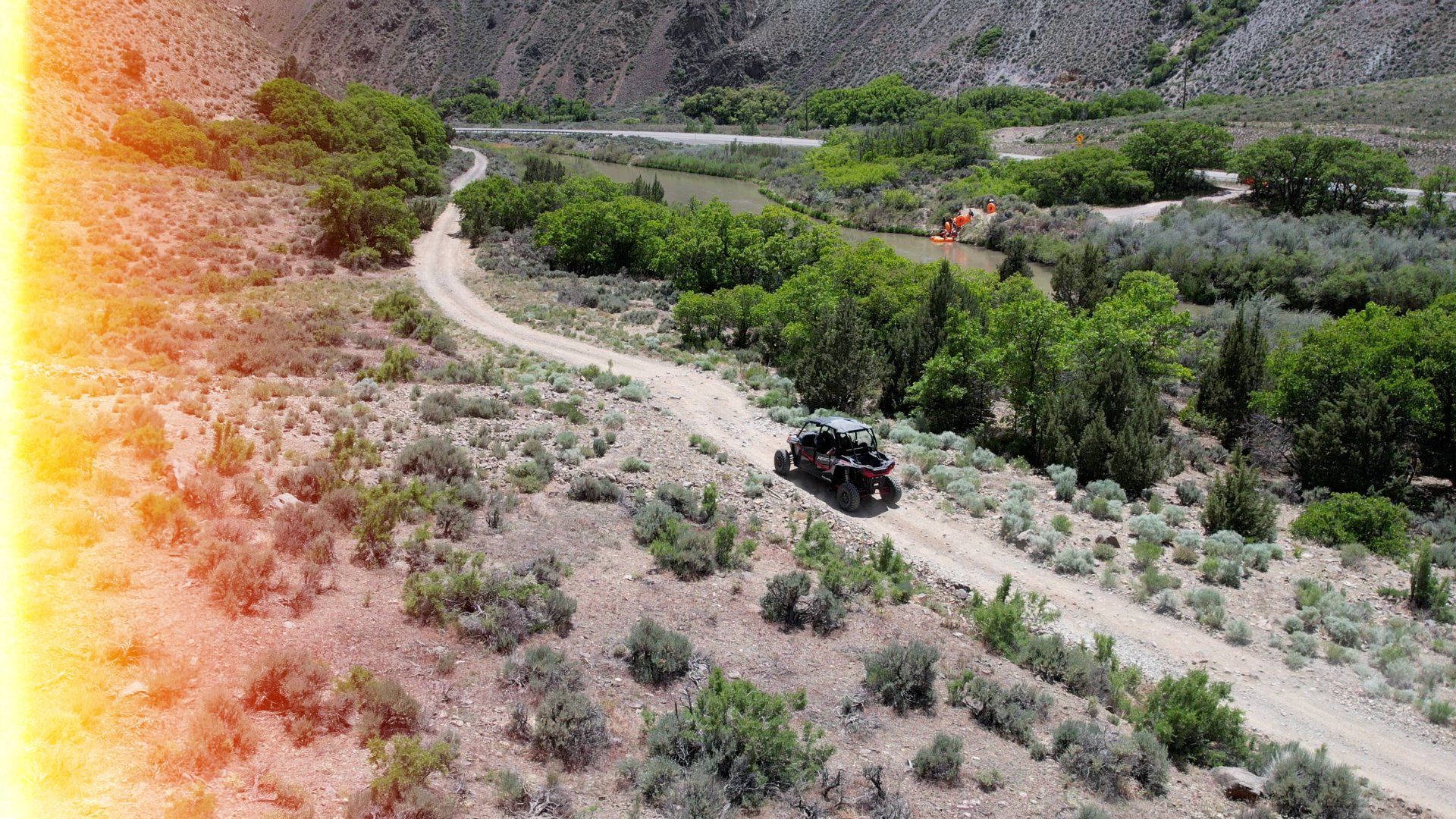 An aerial view of a atv driving down a dirt road.