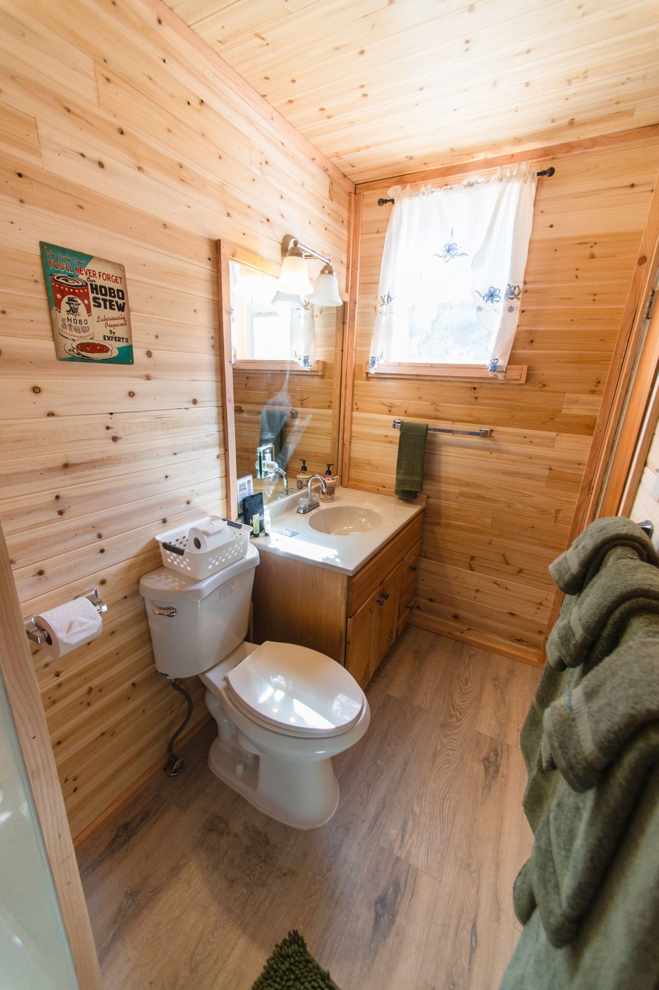 A bathroom in a log cabin with a toilet , sink and mirror.