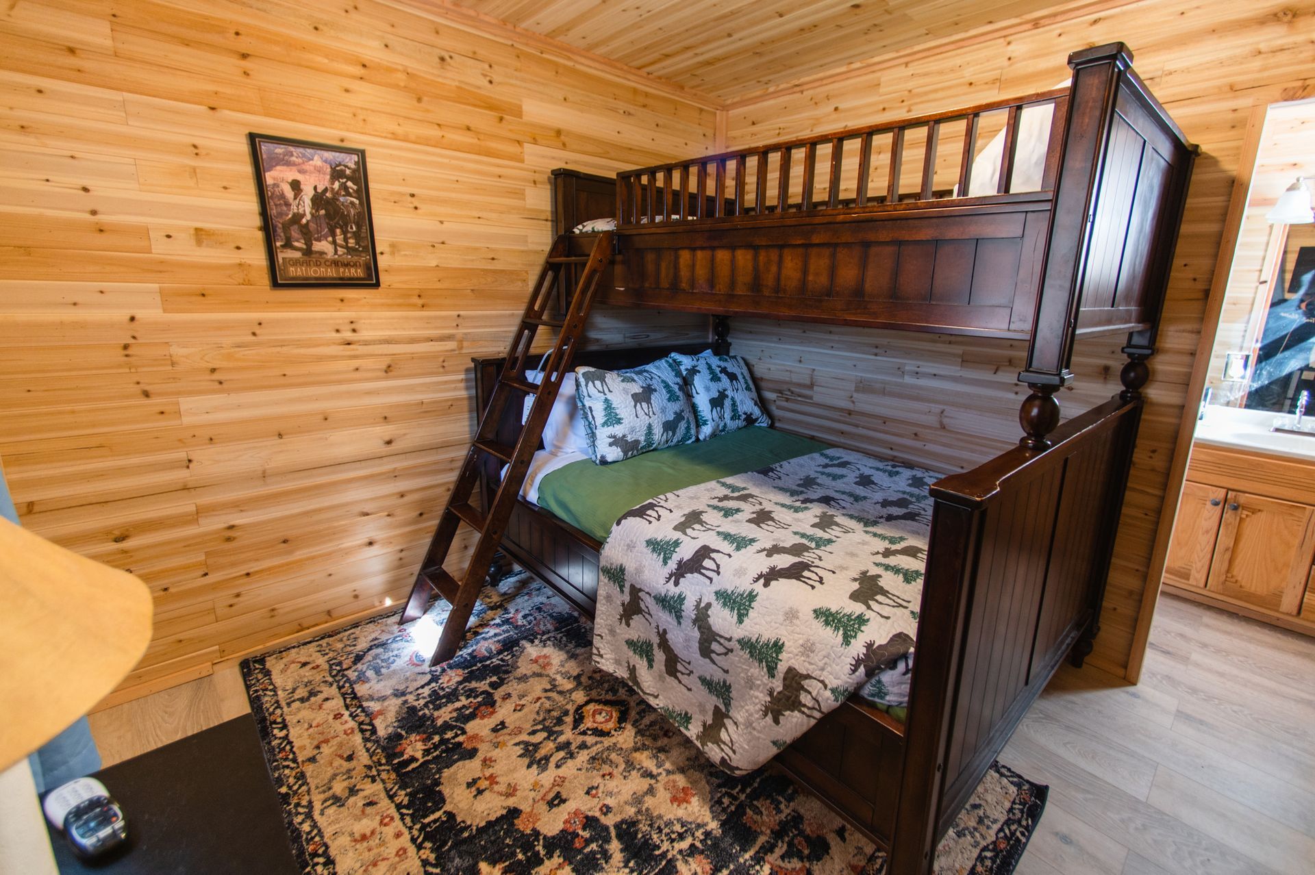 A bunk bed with a ladder in a wooden cabin.