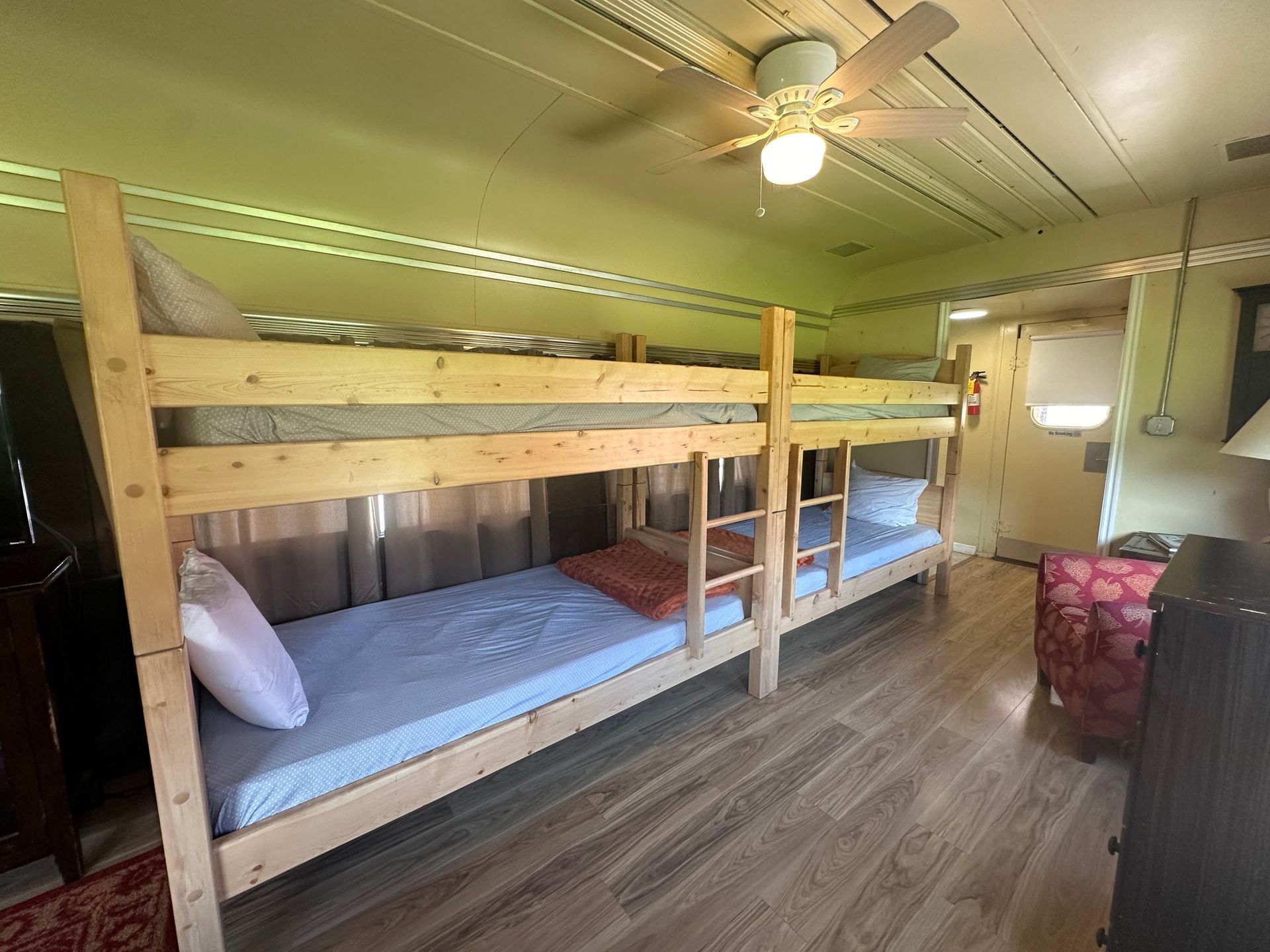 A room with bunk beds and a ceiling fan.