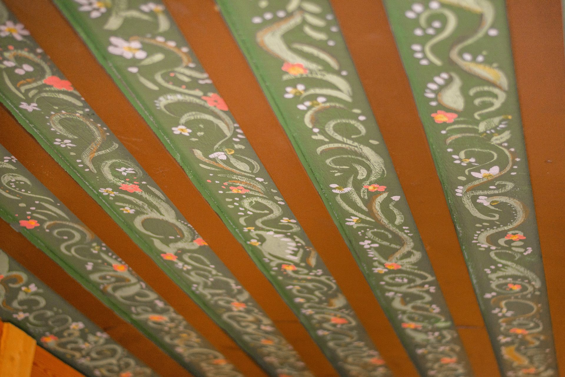 A green and brown striped ceiling with a floral design