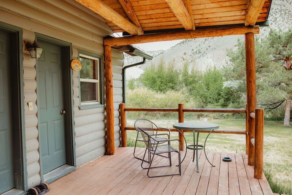 There is a porch with a table and chairs on it.