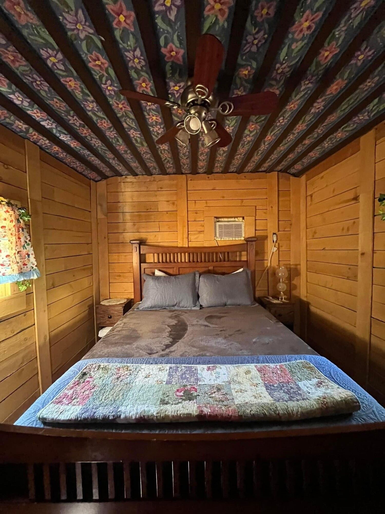 A bedroom with a bed and a ceiling fan.